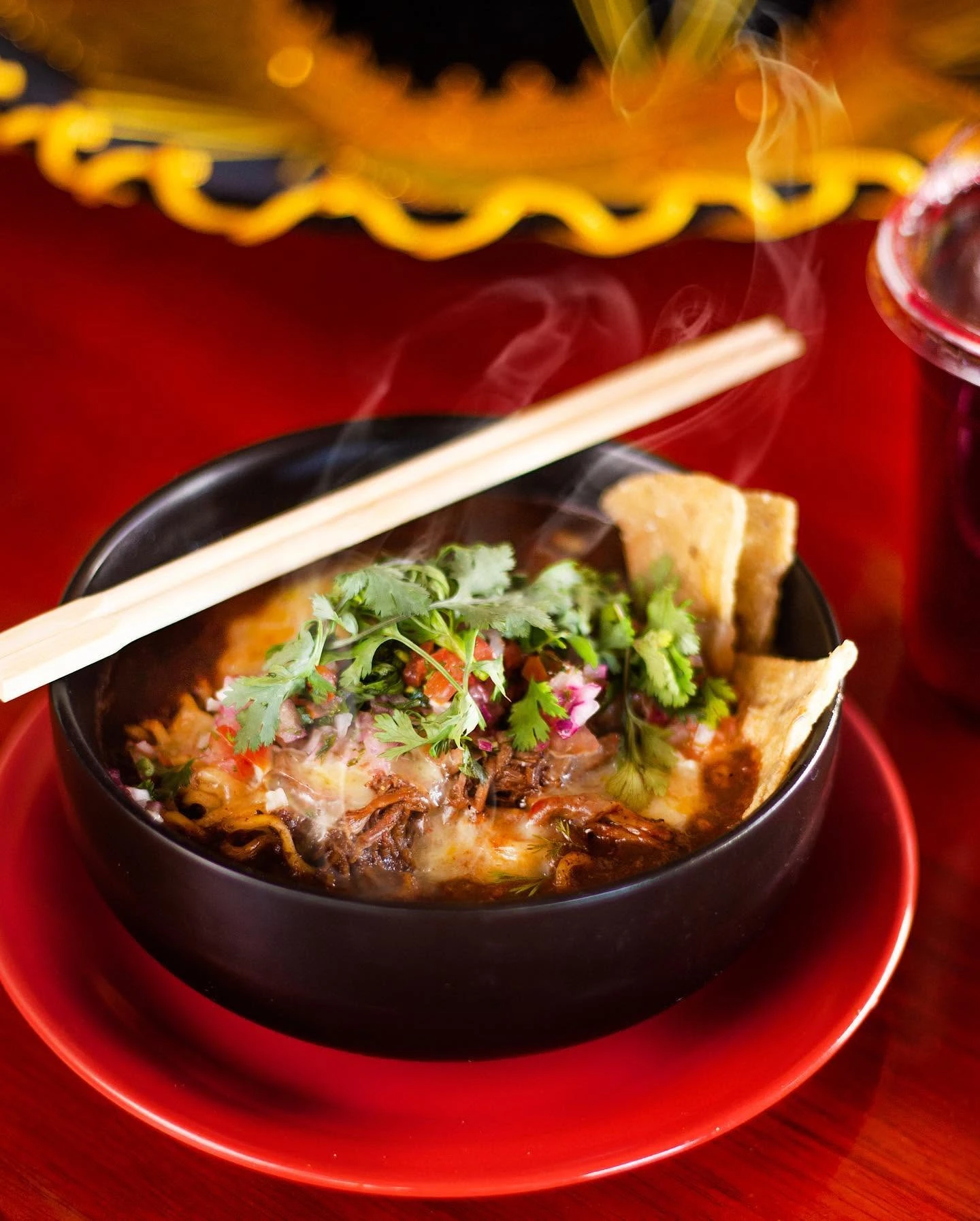 Ramen fusión con carne deshebrada y culantro, humeante